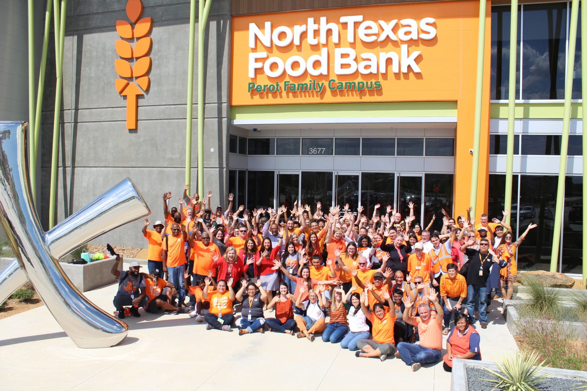 NTFB staff in orange shirts outside of the Perot Family Campus
