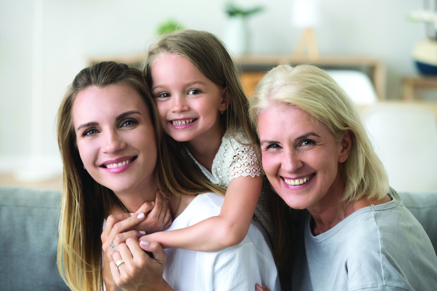 Happy three women generation, smiling young mother piggybacking little kid daughter looking at camera with old grandma, senior grandmother millennial mom and child together, family headshot portrait