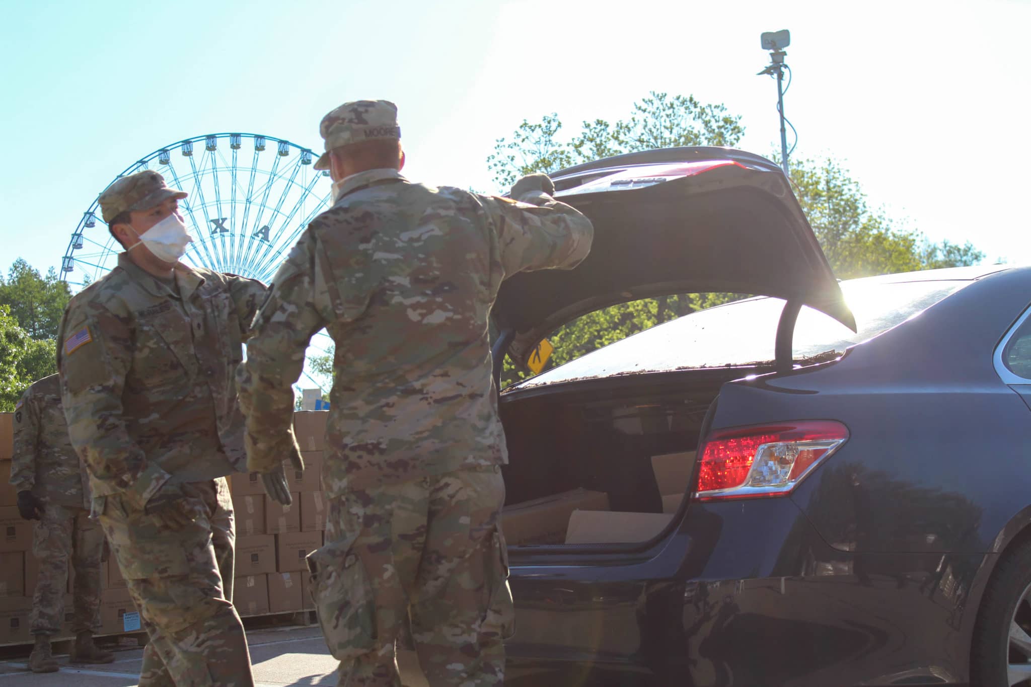 National Guard members putting boxes of food into car trunks at a Fair Park Mobile Pantry distribution led by the North Texas Food Bank
