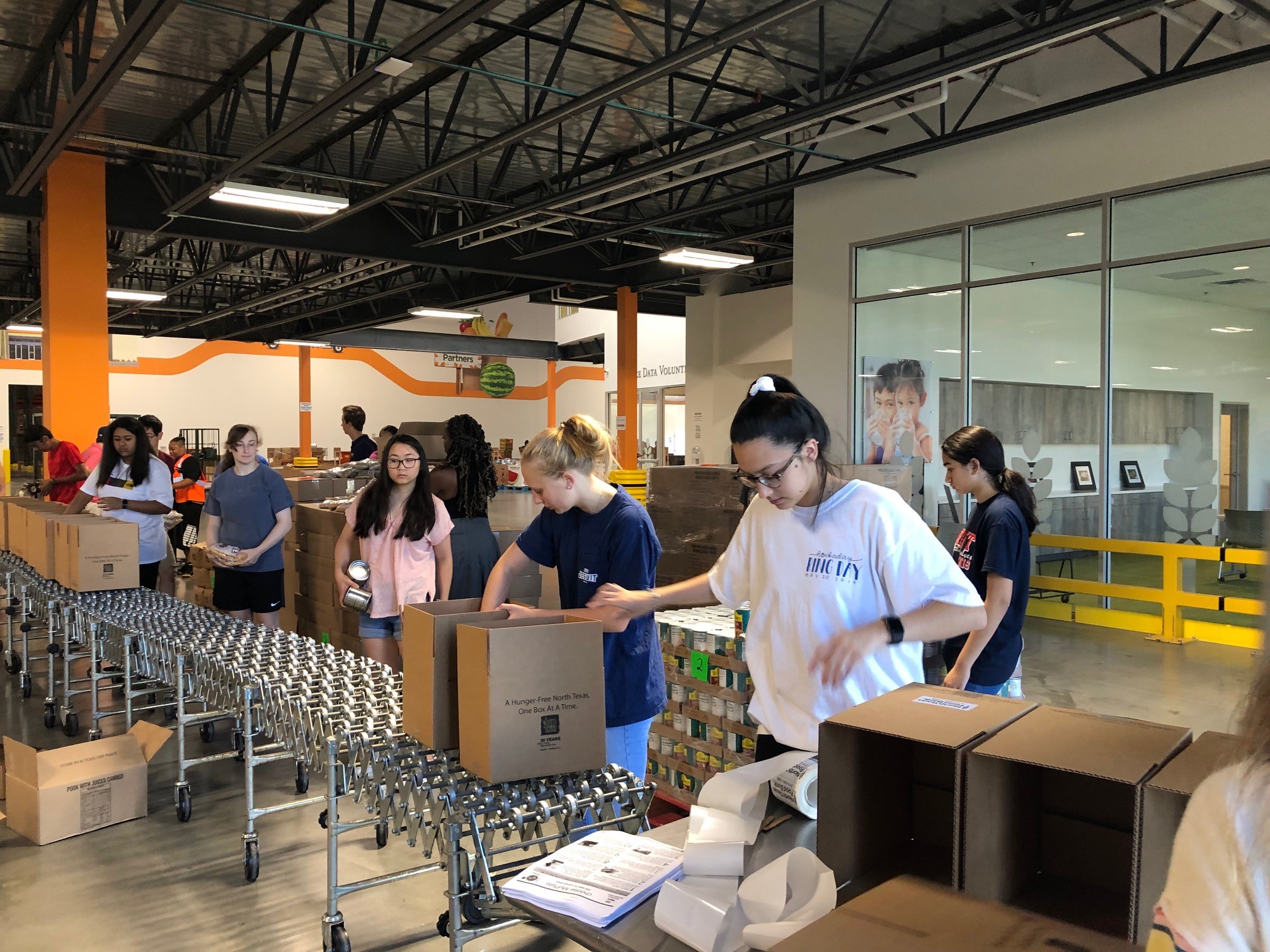Members of the North Texas Food Bank's Young Advocates Council packing boxes of food