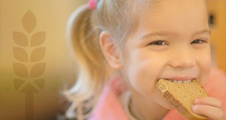 Young girl eating a piece of bread