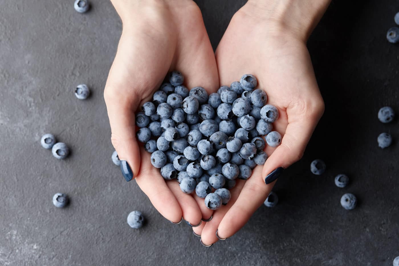 Close up of woman hands holding fresh blueberries.