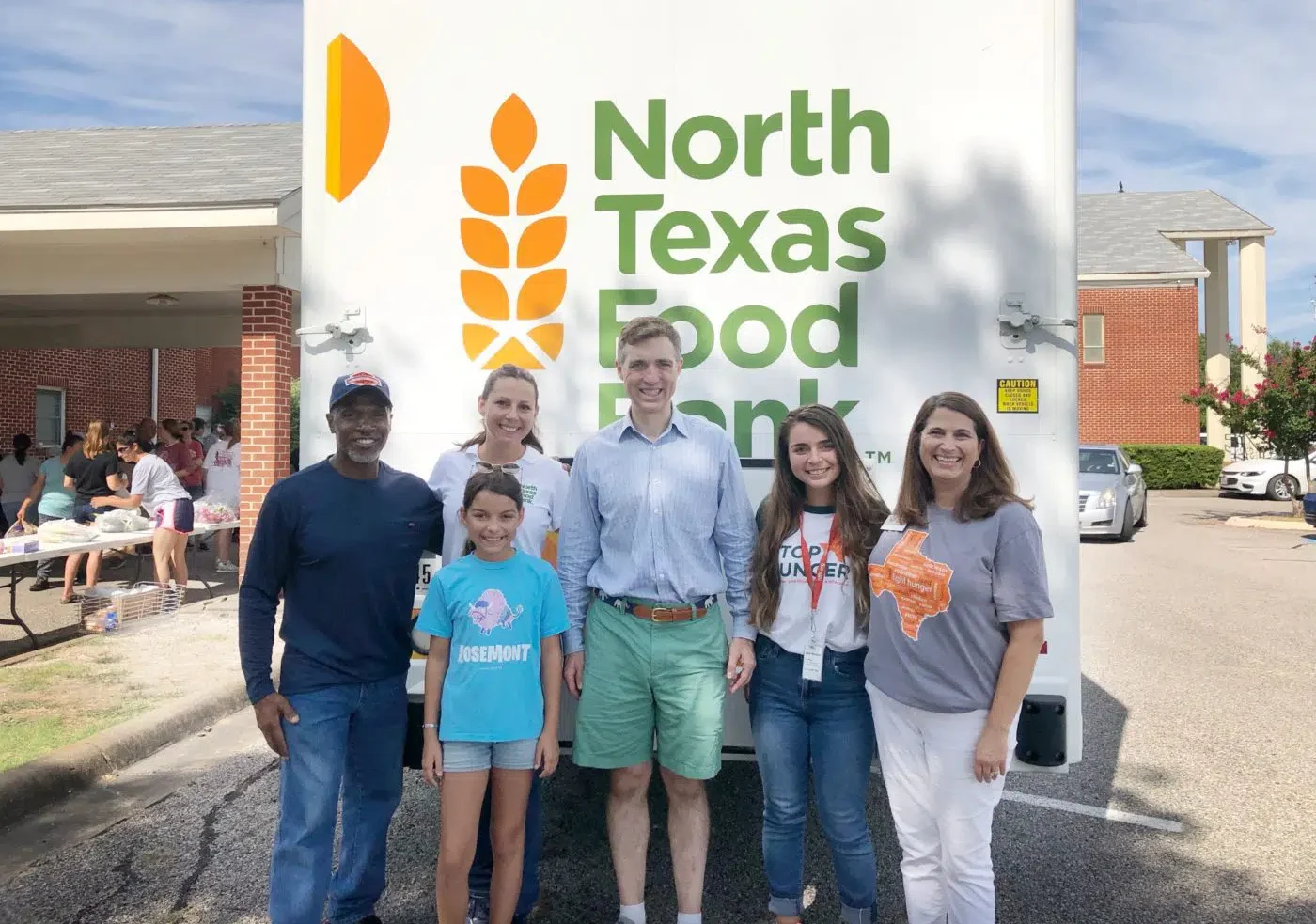 Group of people in front of a North Texas Food Bank sign