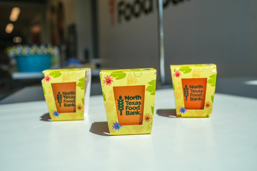 Three yellow planters featuring the North Texas Food Bank logo.