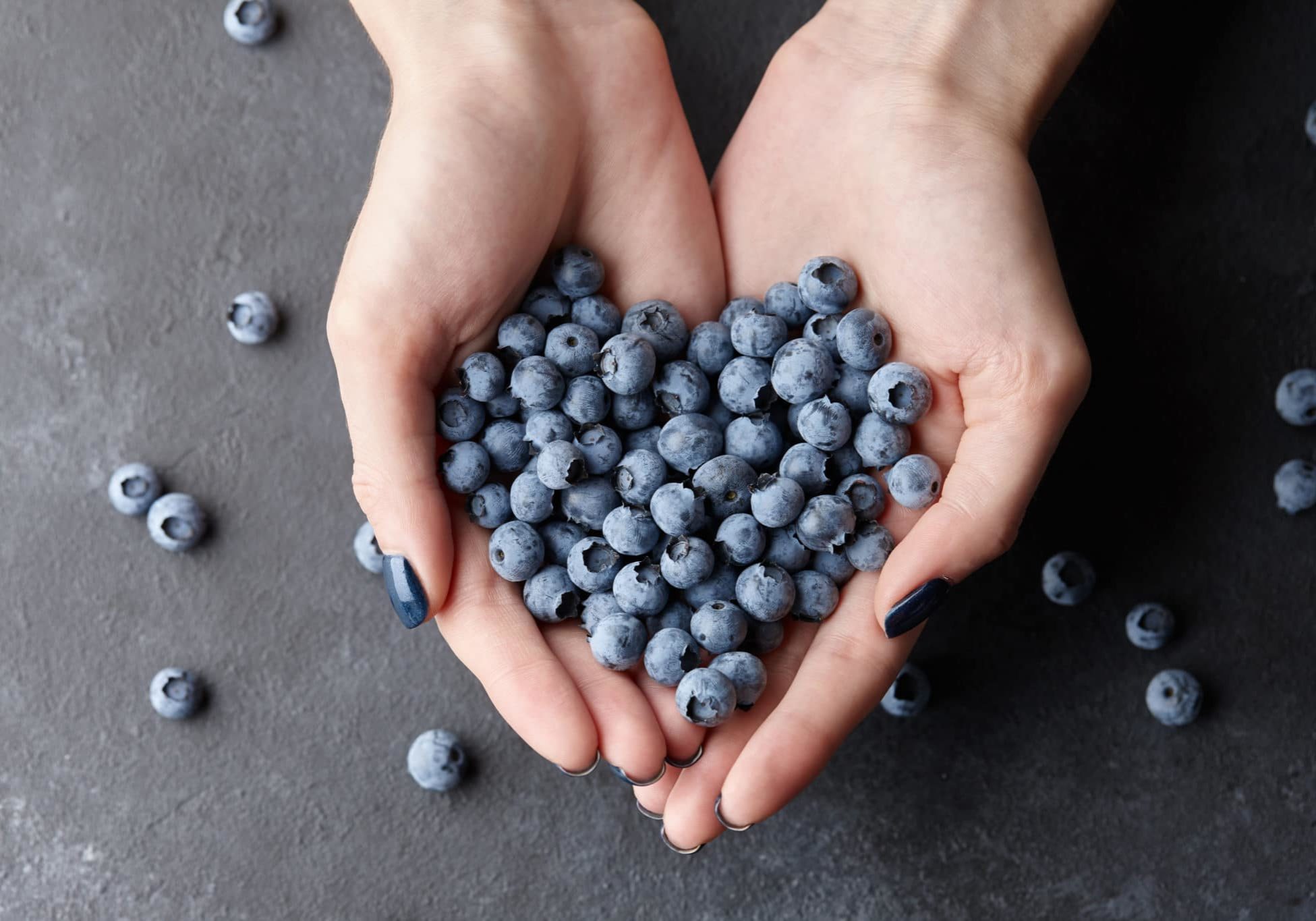Close up of woman hands holding fresh blueberries. Healthy eating, dieting and vegetarian food concept.