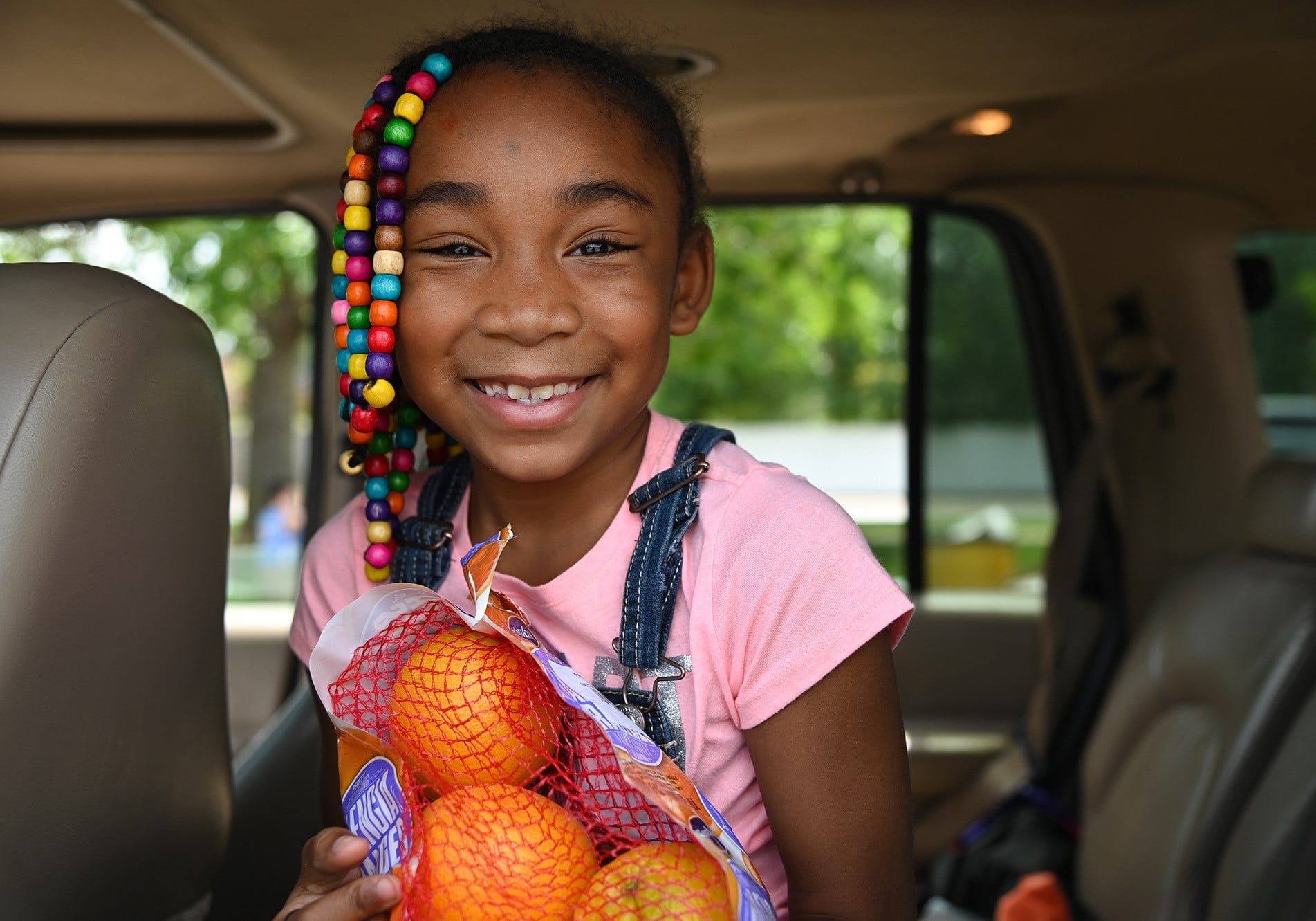JaLisa's face lit up when she saw a bag of oranges loaded into her grandma's car at a Care and Share Food Bank's Mobile Food Pantry.