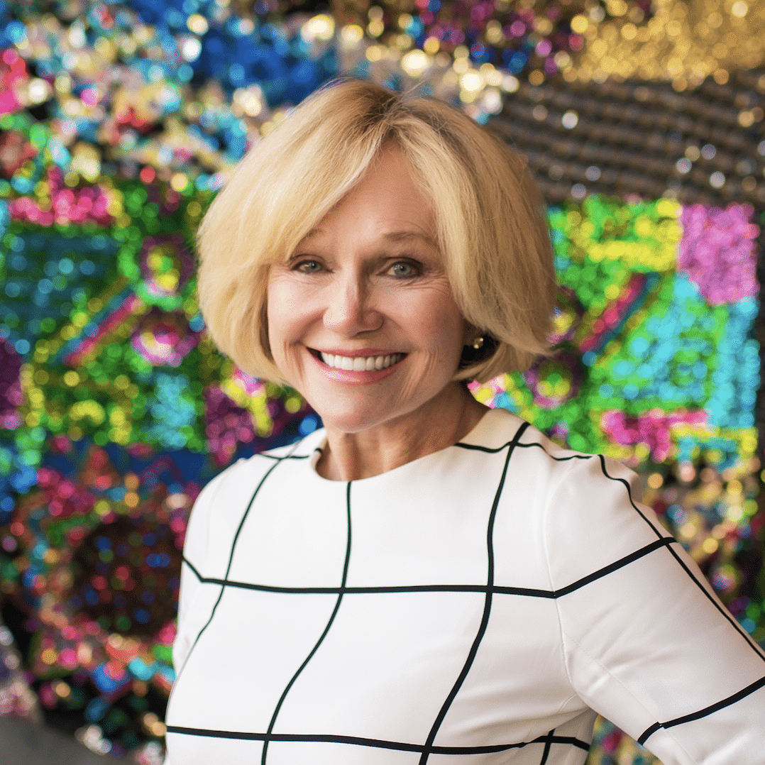 Kathryn Hall standing in front of a multicolor sparkly background
