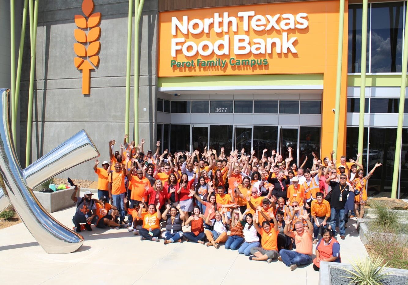 NTFB staff in orange shirts outside of the Perot Family Campus